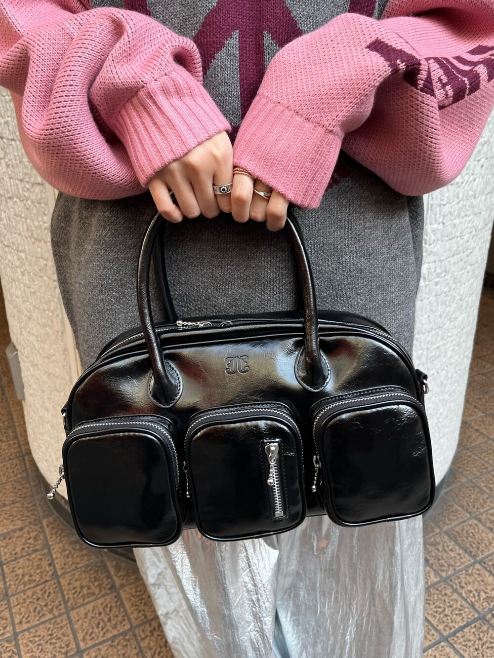 グレー系のニット/セーター、ブラック系のボストンバッグ、シルバー系のスカートを着用したレディースの冬コーディネートの8枚目の写真