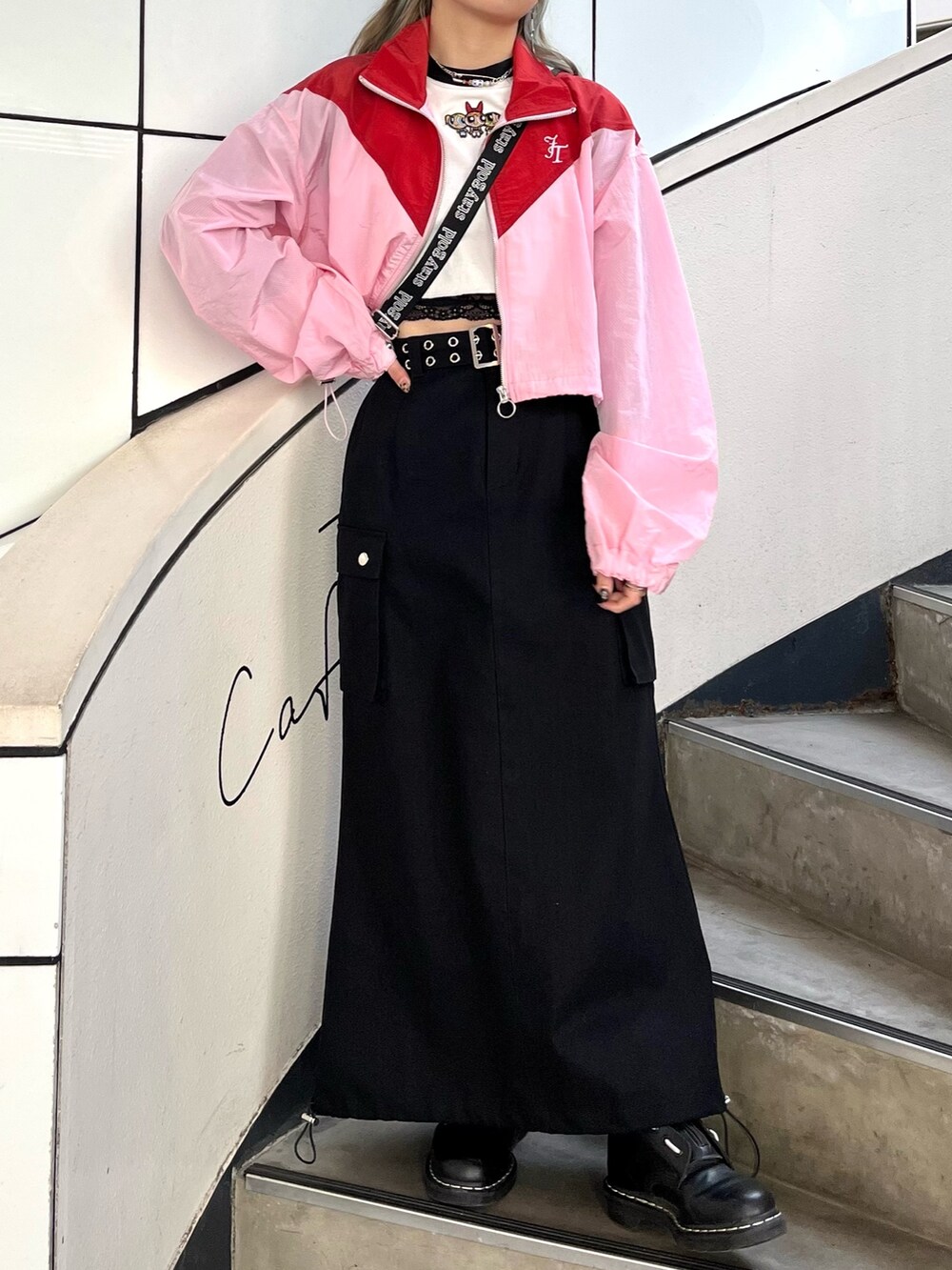 ブラック系のスカート、ピンク系のブルゾン、ホワイト系のTシャツ/カットソーを着用したレディースの春コーディネートの3枚目の写真