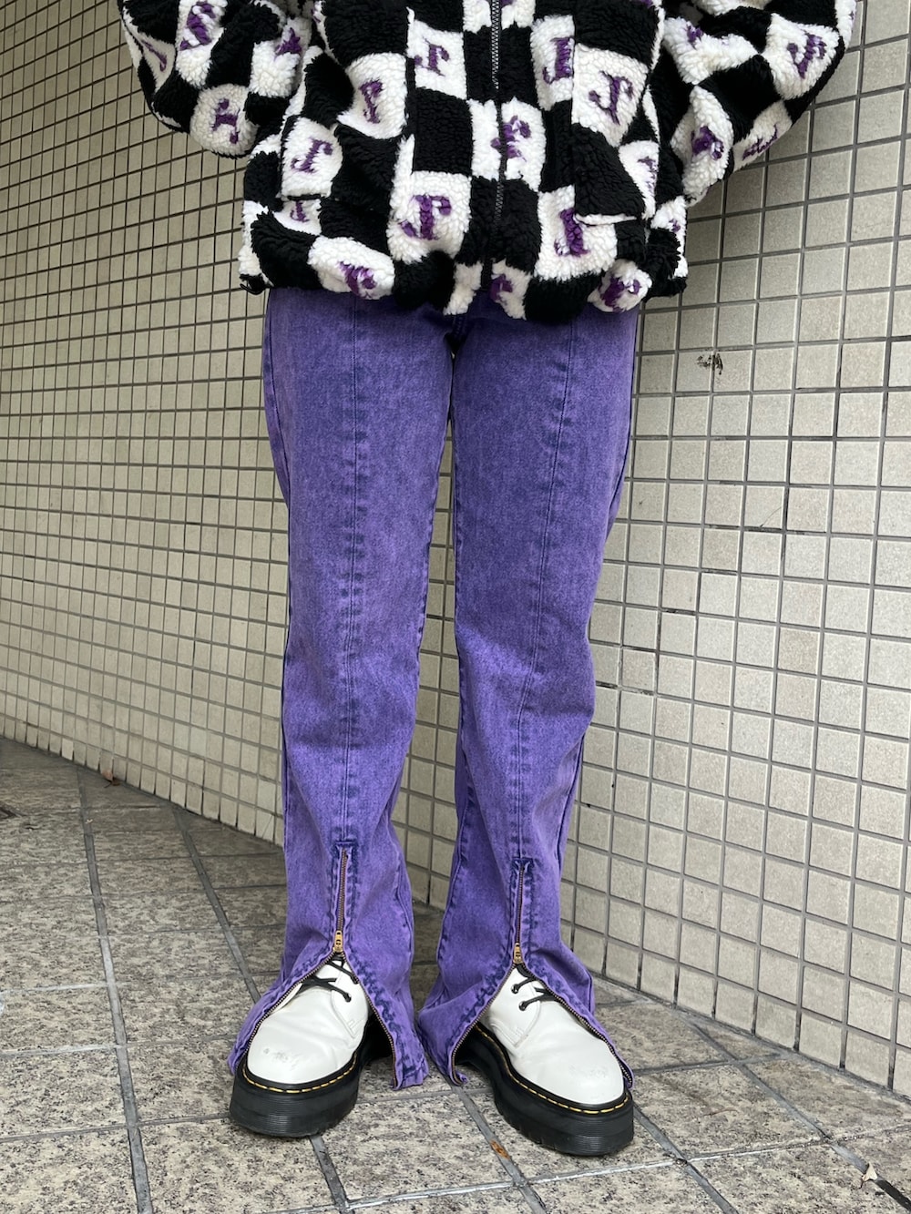 パープル系のデニムパンツ、ブラック系のブルゾンを着用したレディースの秋コーディネートの7枚目の写真