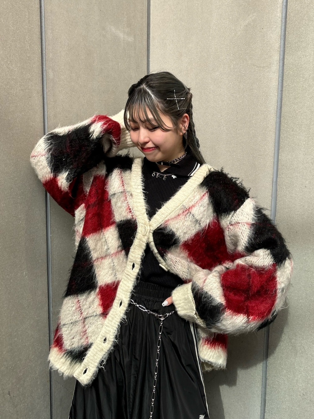 ブラック系のスカート、ホワイト系のカーディガン/ボレロ、ブラック系のTシャツ/カットソーを着用したレディースの秋コーディネートの4枚目の写真