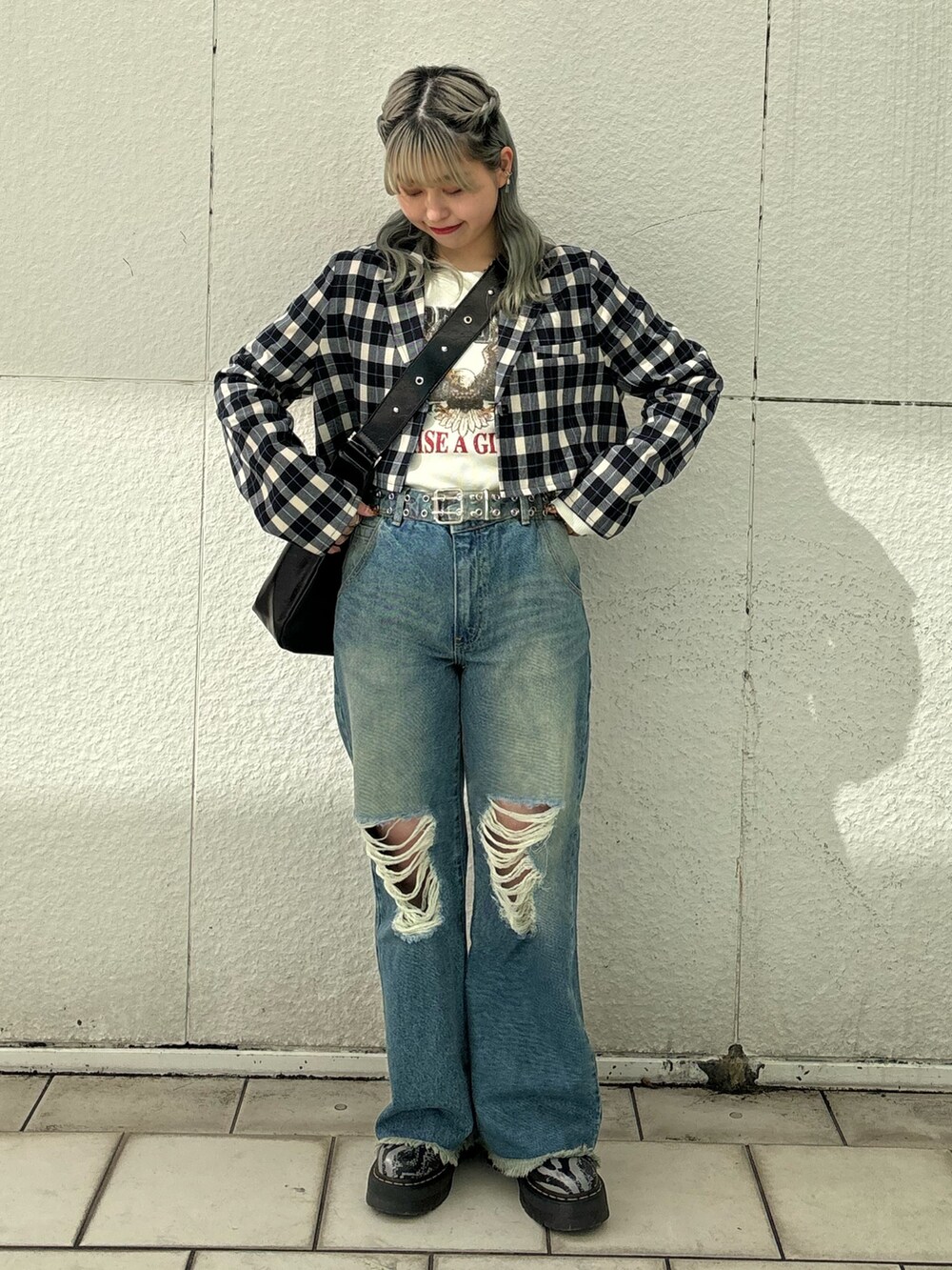 ブルー系のデニムパンツ、ブラック系のショルダーバッグ、ホワイト系のTシャツ/カットソーを着用したレディースの冬コーディネートの5枚目の写真