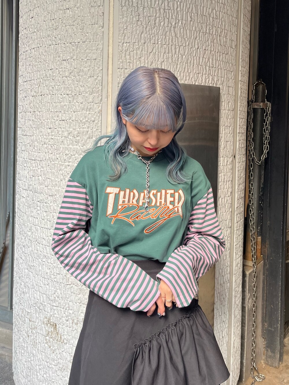 グリーン系のTシャツ/カットソー、ブラック系のスカート、シルバー系のネックレスを着用したレディースの秋コーディネートの6枚目の写真