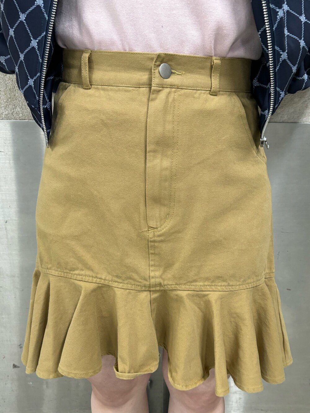 ベージュ系のスカート、ピンク系のニット/セーター、ブルー系のジャージを着用したレディースの春コーディネートの8枚目の写真