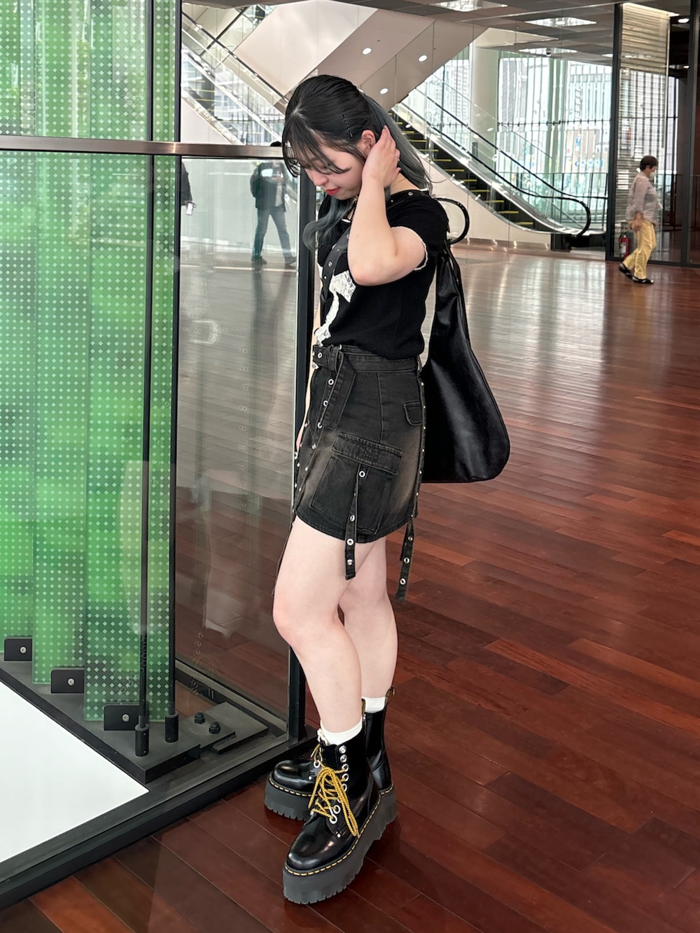 ブラック系のスカート、ブラック系のTシャツ/カットソー、ブラック系のショルダーバッグを着用したレディースの春コーディネートの4枚目の写真