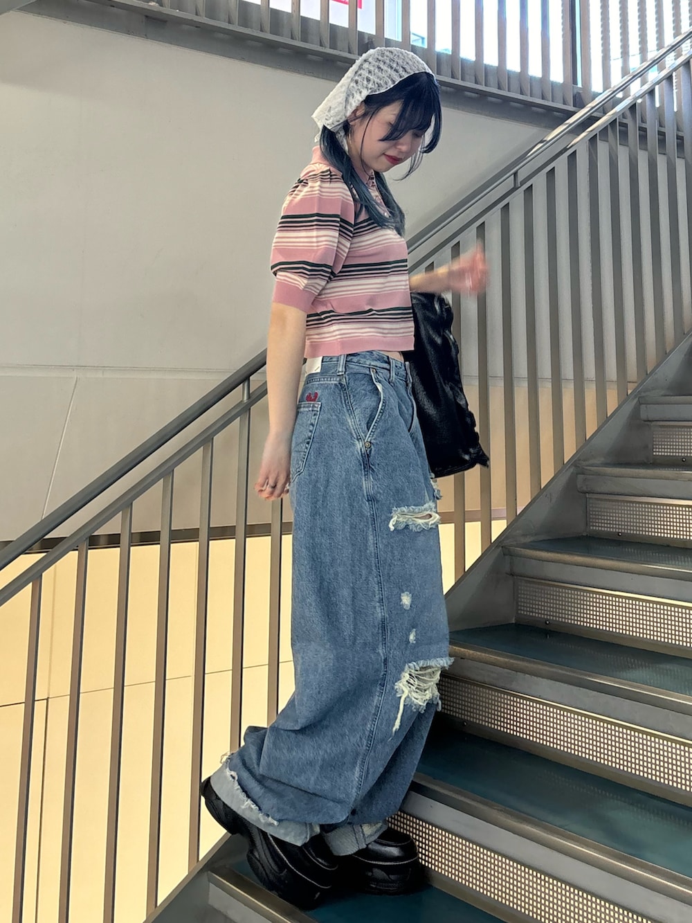 ブラック系のトートバッグ、ブルー系のデニムパンツ、ブルー系のデニムパンツを着用したレディースの春コーディネートの2枚目の写真