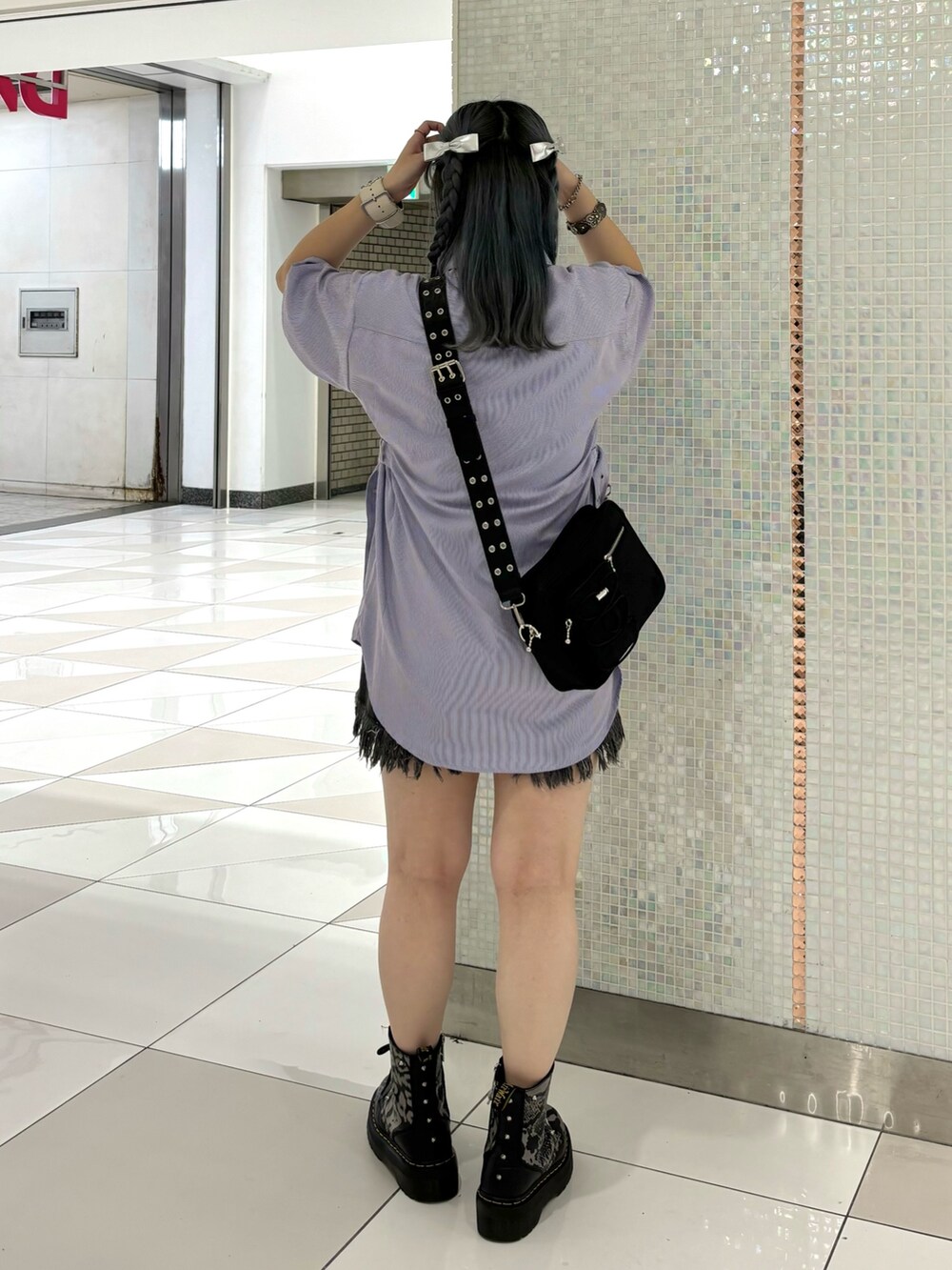 ブラック系のデニムパンツ、ブラック系のショルダーバッグ、パープル系のシャツ/ブラウスを着用したレディースの夏コーディネートの3枚目の写真