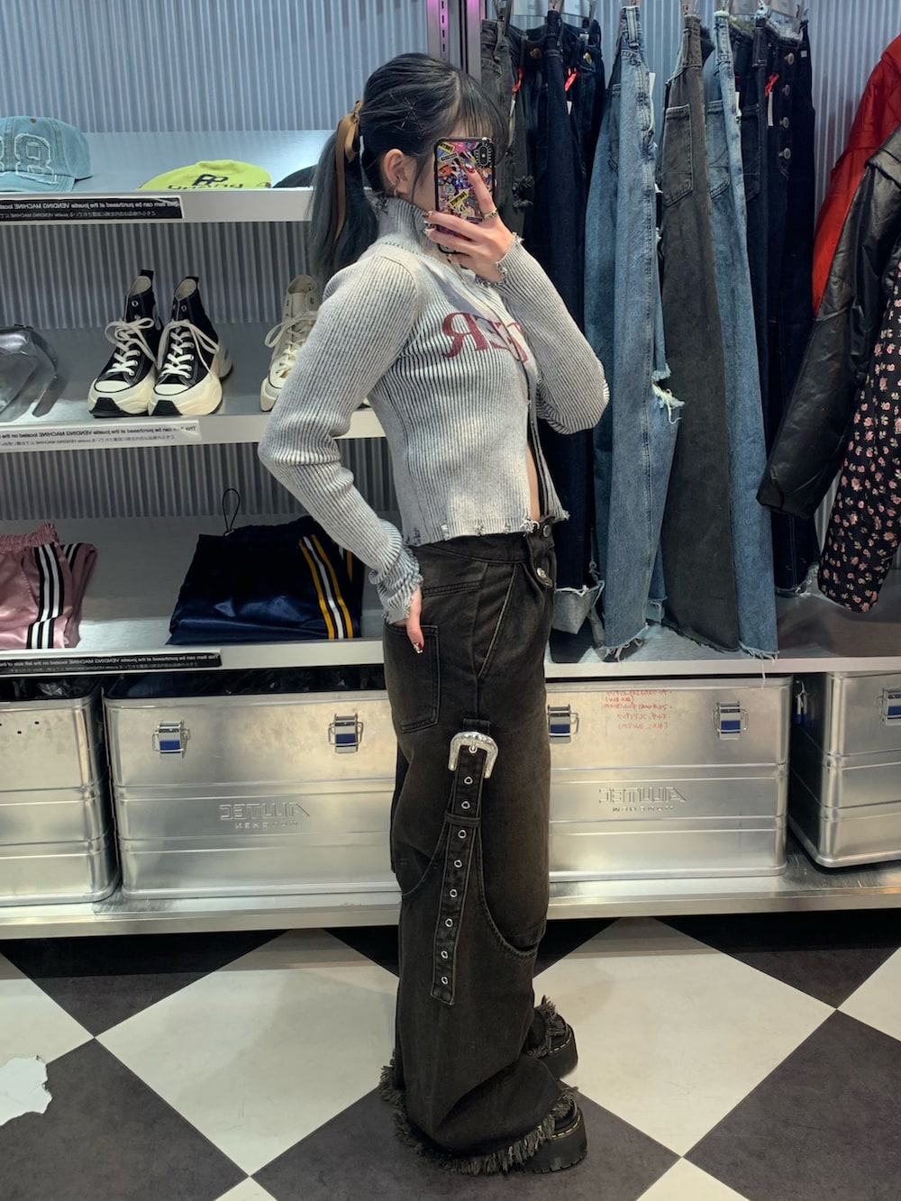 ブラック系のデニムパンツ、ブラック系のその他シューズ、グレー系のニット/セーターを着用したレディースの春コーディネートの2枚目の写真