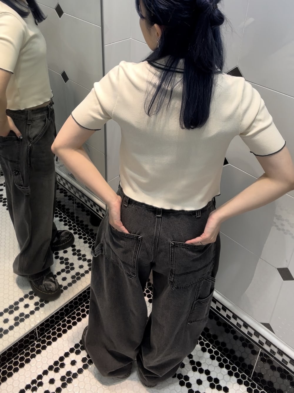 ブラック系のデニムパンツ、ホワイト系のポロシャツを着用したレディースの夏コーディネートの3枚目の写真
