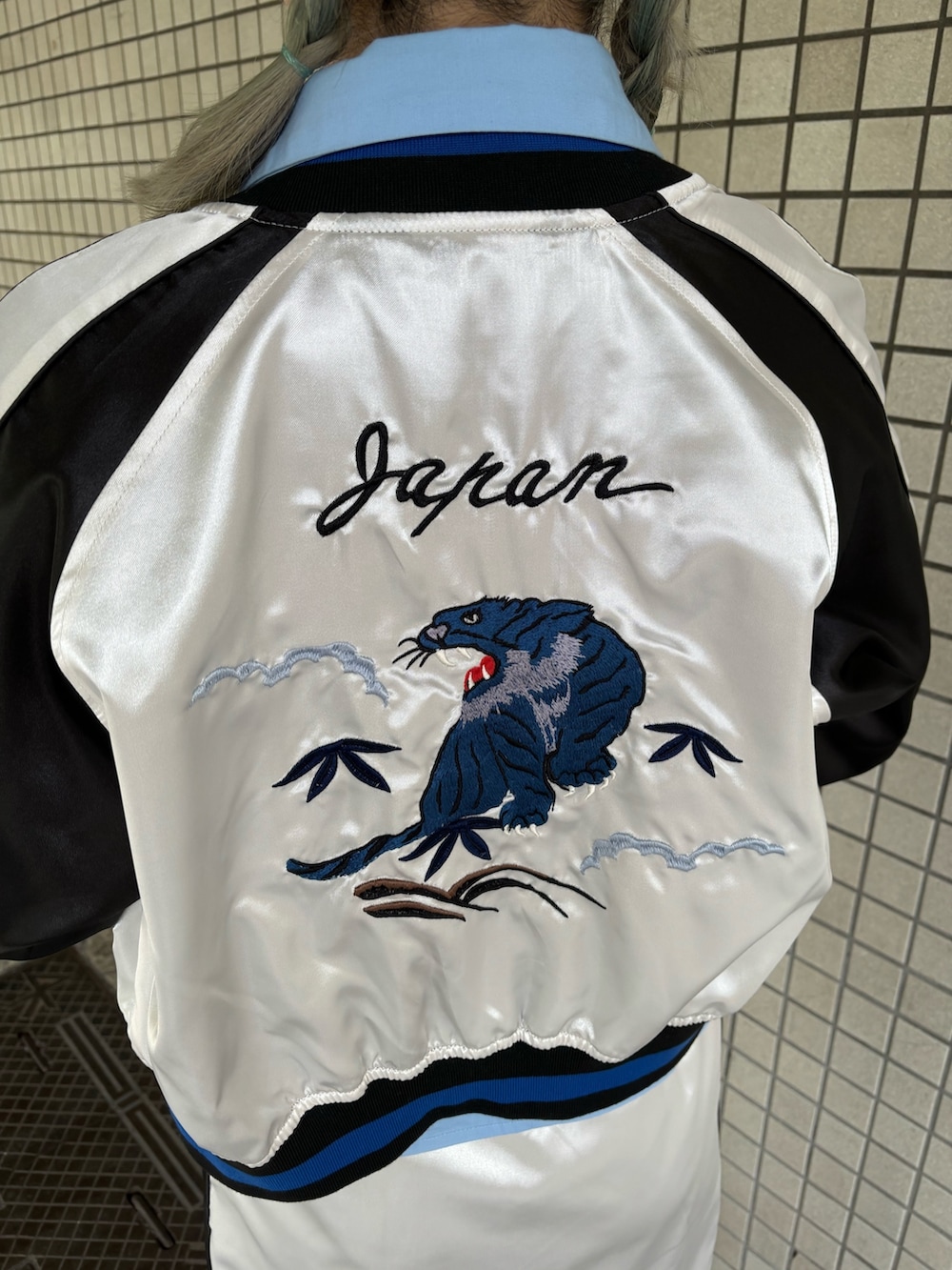 ホワイト系のスカート、ブルー系のシャツ/ブラウス、ブラック系のニット/セーターを着用したレディースの春コーディネートの9枚目の写真