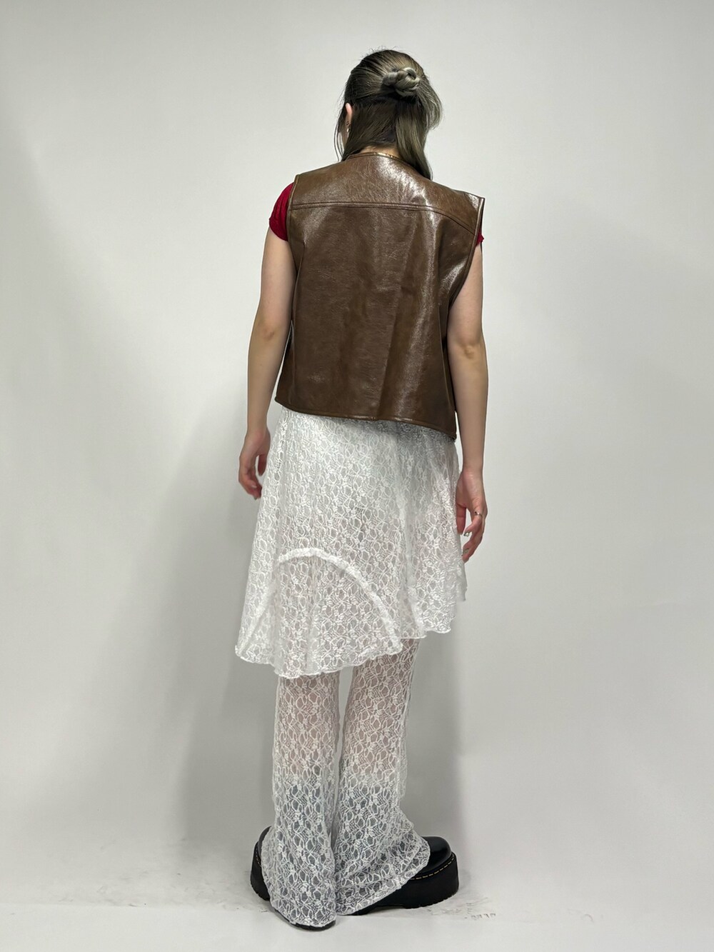 ホワイト系のその他パンツ、レッド系のニット/セーター、ブラウン系のベストを着用したレディースの春コーディネートの3枚目の写真