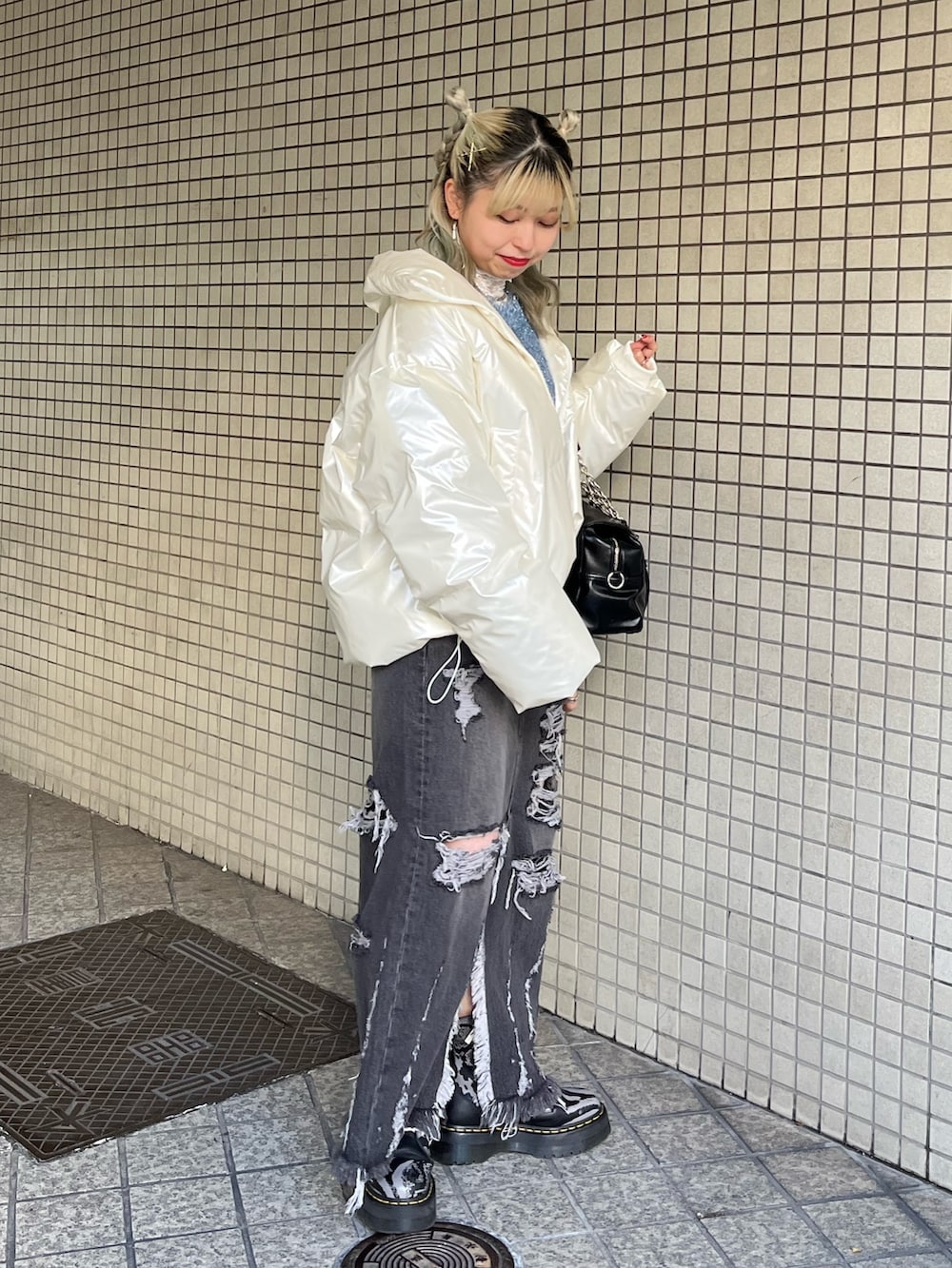 ホワイト系のTシャツ/カットソー、ブラック系のハンドバッグ、ブルー系のニット/セーターを着用したレディースの冬コーディネートの6枚目の写真