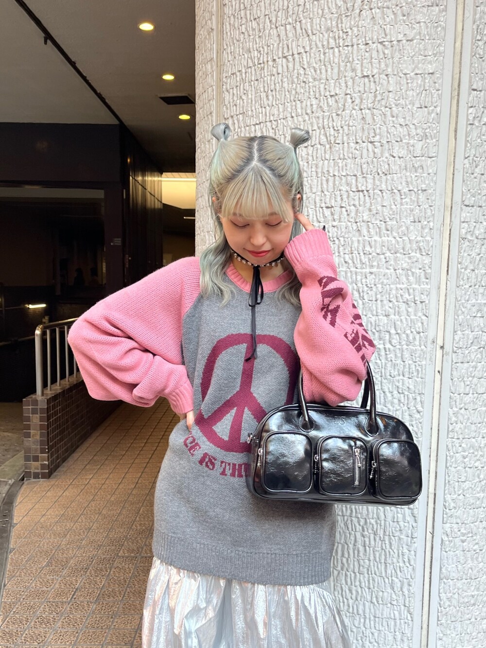 グレー系のニット/セーター、ブラック系のボストンバッグ、シルバー系のスカートを着用したレディースの冬コーディネートの5枚目の写真