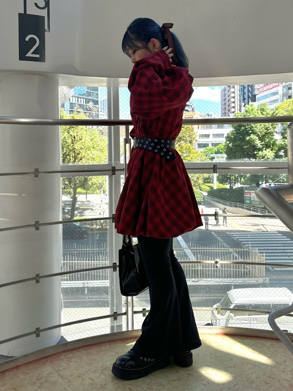 レッド系のワンピース、ブラック系のハンドバッグ、ブラック系のその他パンツを着用したレディースの秋コーディネートの3枚目の写真