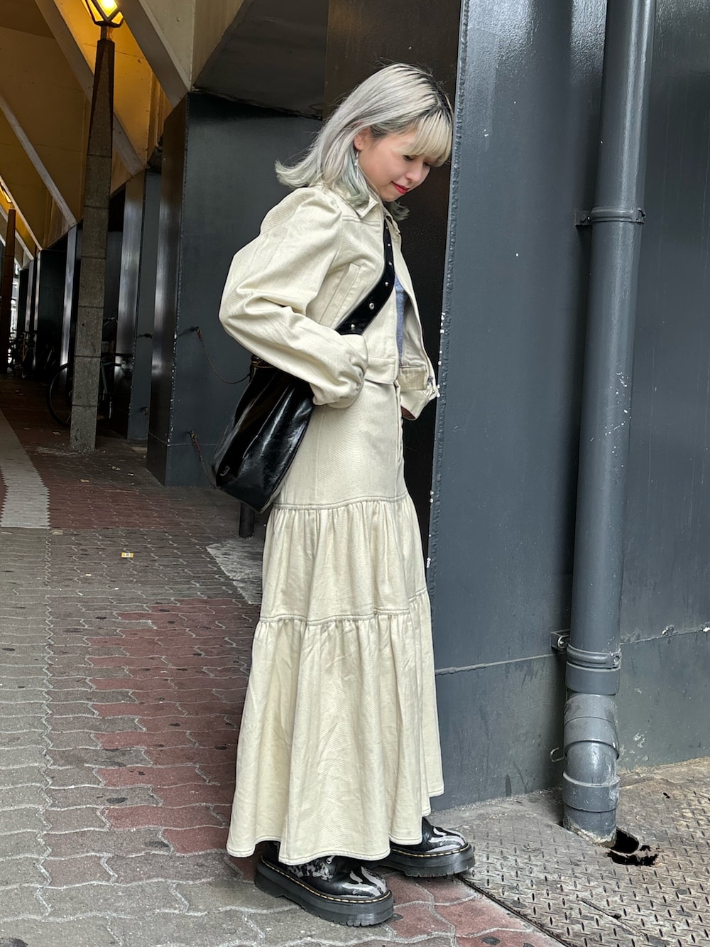 ブラック系のショルダーバッグ、ブルー系のTシャツ/カットソー、ホワイト系のワンピースを着用したレディースの春コーディネートの2枚目の写真