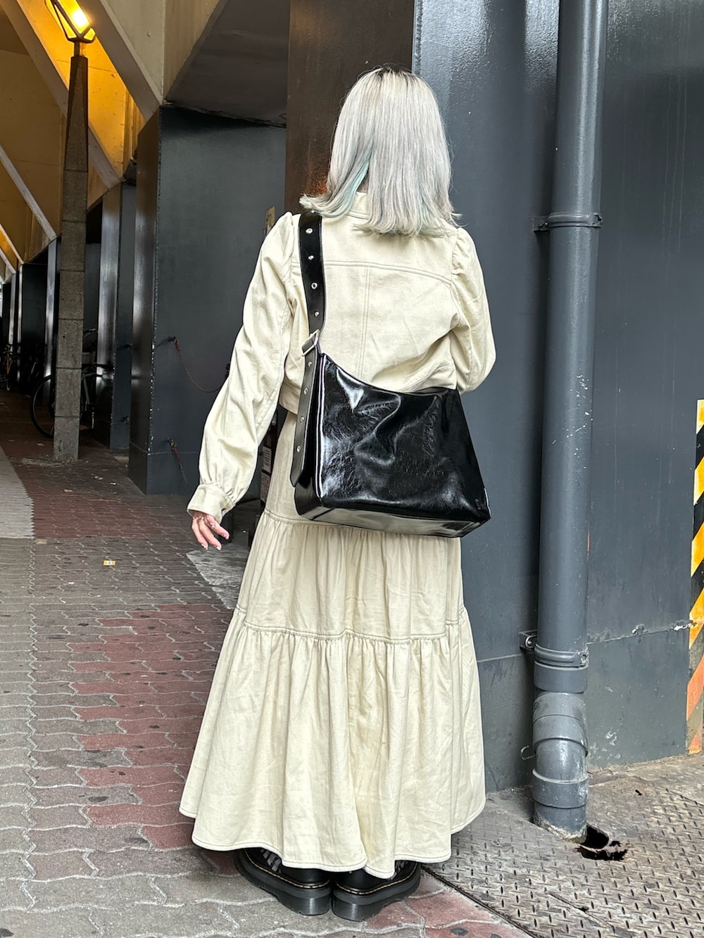 ブラック系のショルダーバッグ、ブルー系のTシャツ/カットソー、ホワイト系のワンピースを着用したレディースの春コーディネートの3枚目の写真