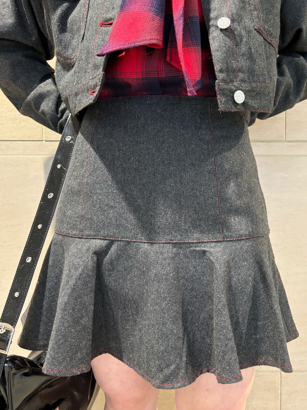 グレー系のワンピース、レッド系のシャツ/ブラウス、ブラック系のショルダーバッグを着用したレディースの秋コーディネートの7枚目の写真