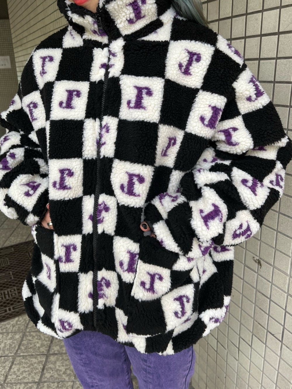 パープル系のデニムパンツ、ブラック系のブルゾンを着用したレディースの秋コーディネートの6枚目の写真