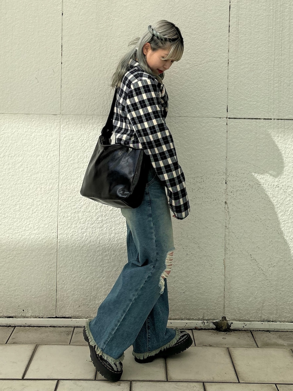 ブルー系のデニムパンツ、ブラック系のショルダーバッグ、ホワイト系のTシャツ/カットソーを着用したレディースの冬コーディネートの2枚目の写真