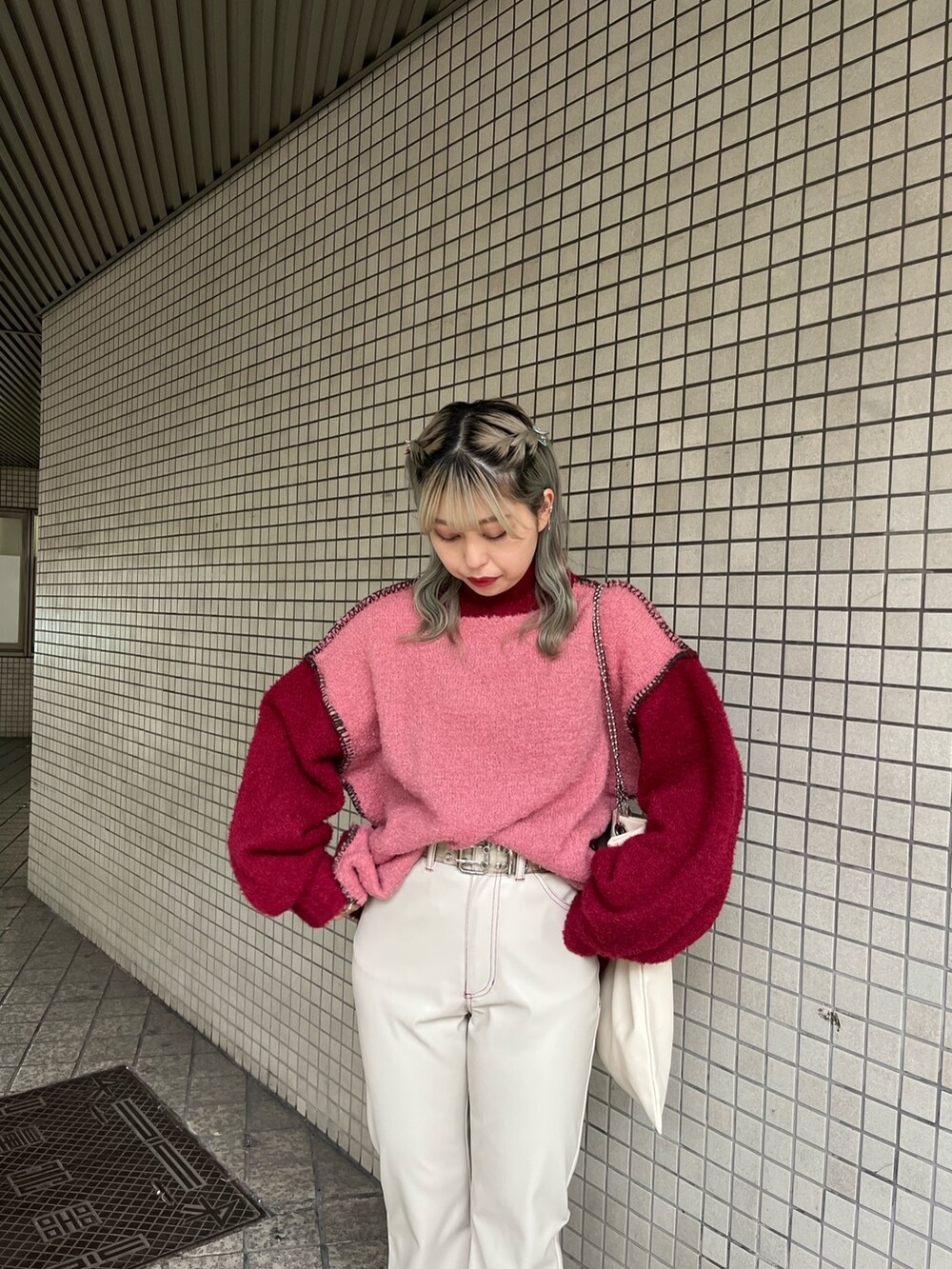 ホワイト系のハンドバッグ、レッド系のニット/セーター、ホワイト系のその他パンツを着用したレディースの冬コーディネートの4枚目の写真