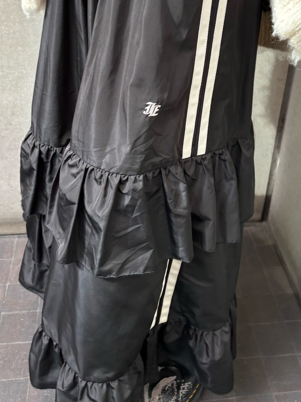 ブラック系のスカート、ホワイト系のカーディガン/ボレロ、ブラック系のTシャツ/カットソーを着用したレディースの秋コーディネートの9枚目の写真