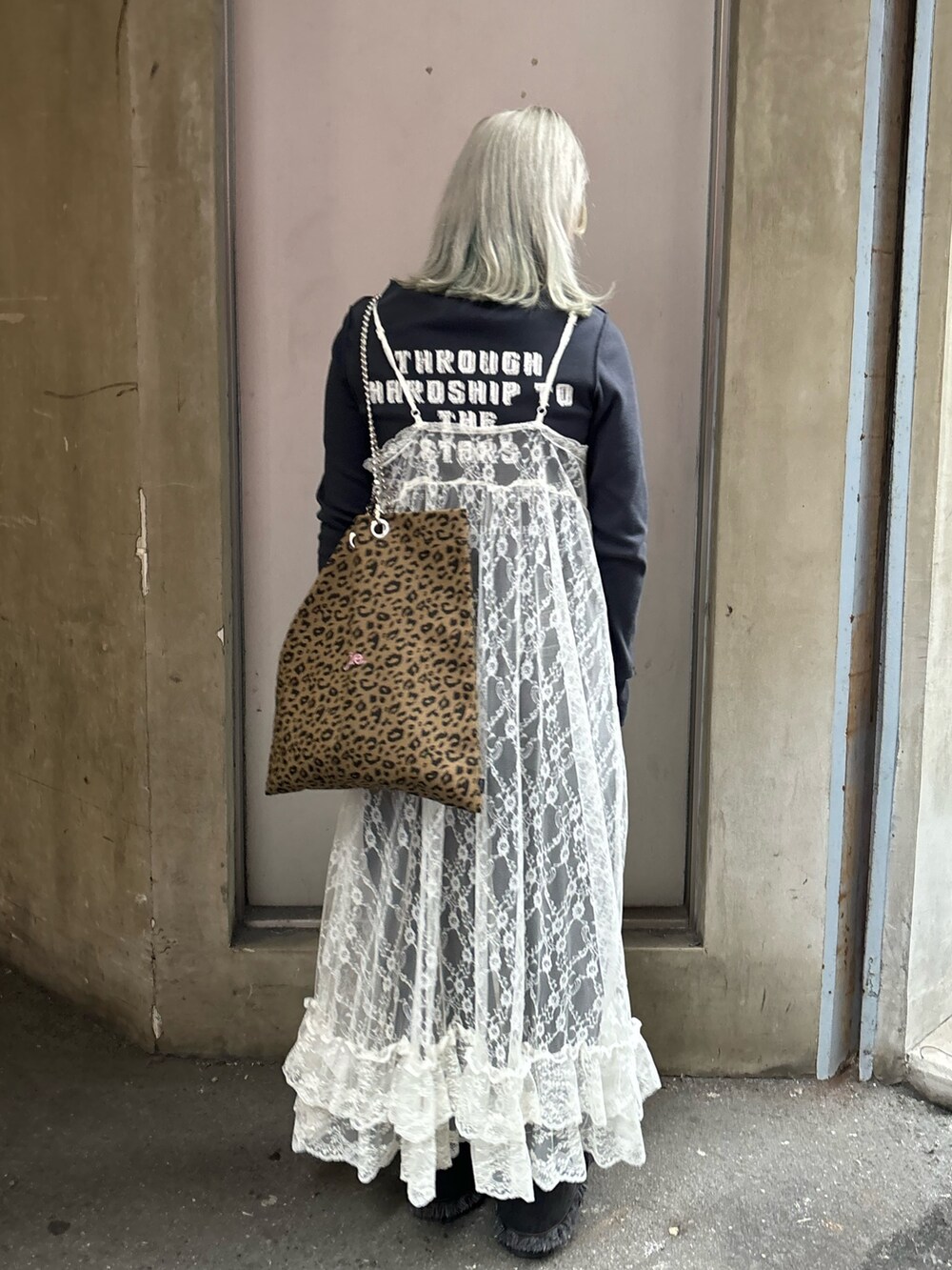 ホワイト系のワンピース、ブラック系のデニムパンツ、その他のトートバッグを着用したレディースの春コーディネートの3枚目の写真