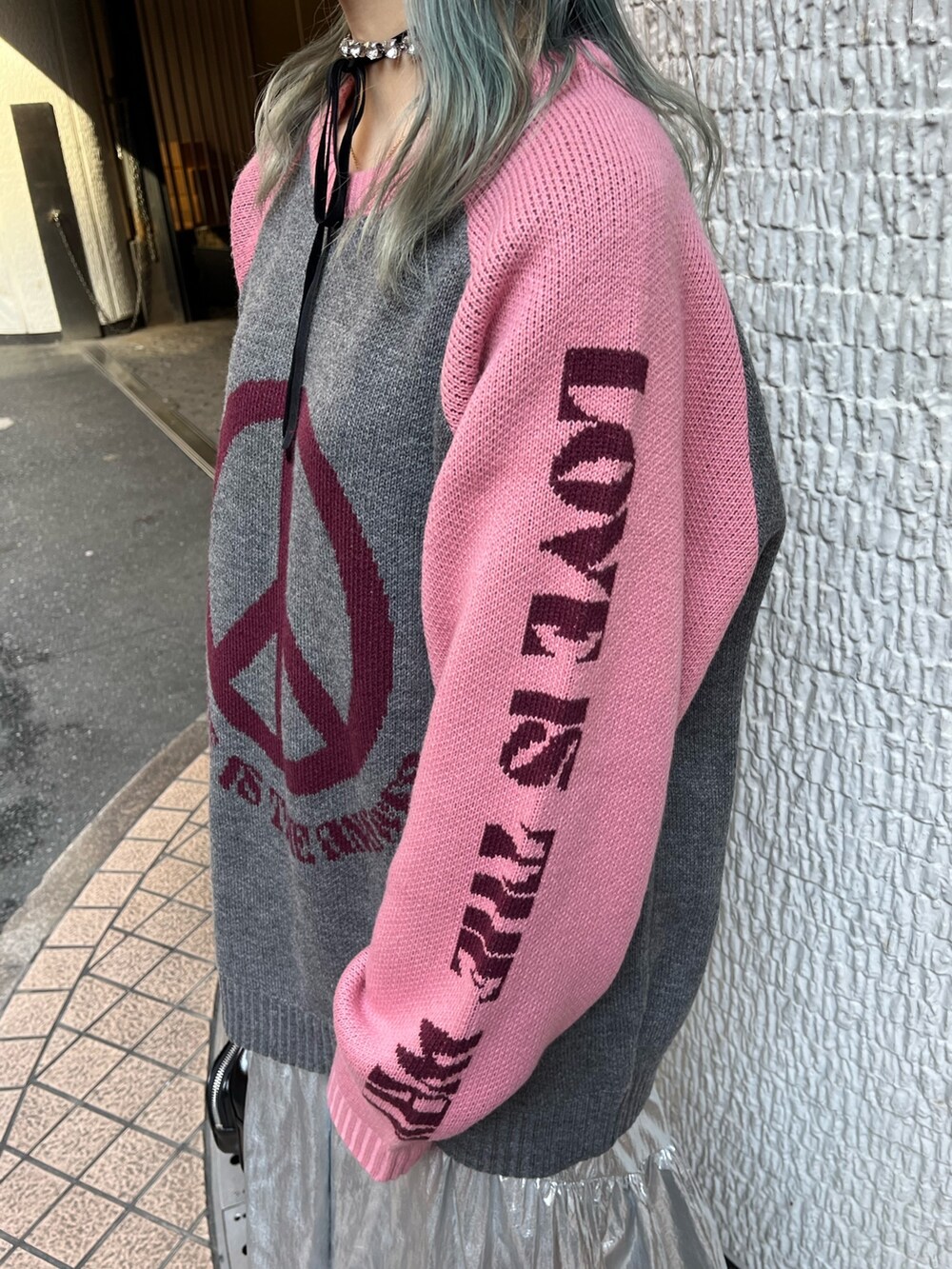 グレー系のニット/セーター、ブラック系のボストンバッグ、シルバー系のスカートを着用したレディースの冬コーディネートの7枚目の写真