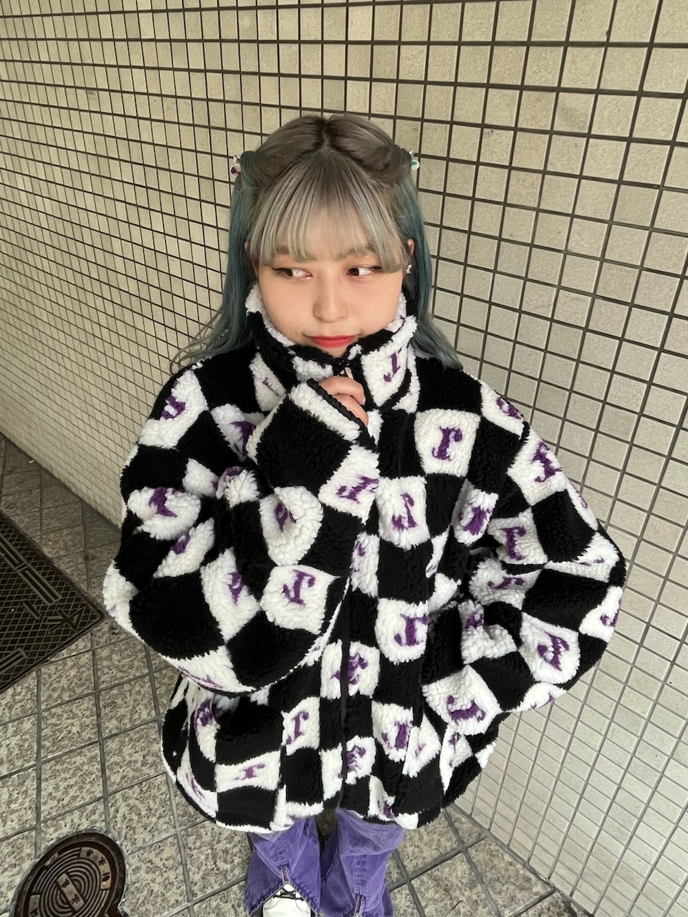 パープル系のデニムパンツ、ブラック系のブルゾンを着用したレディースの秋コーディネートの5枚目の写真