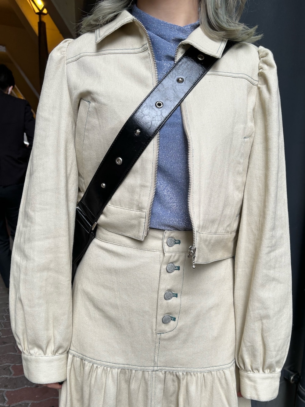 ブラック系のショルダーバッグ、ブルー系のTシャツ/カットソー、ホワイト系のワンピースを着用したレディースの春コーディネートの6枚目の写真