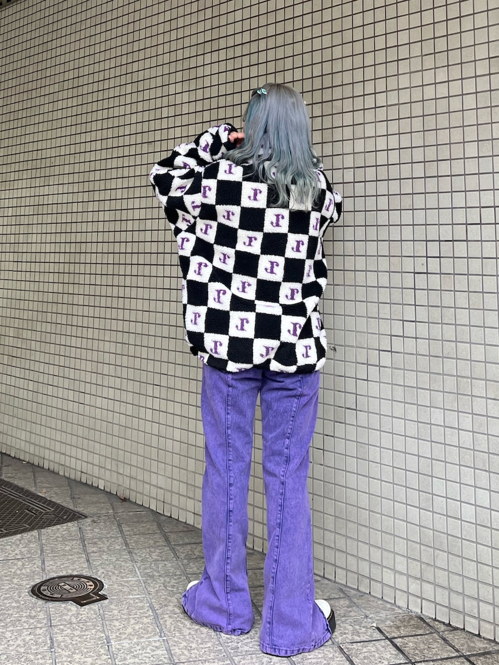 パープル系のデニムパンツ、ブラック系のブルゾンを着用したレディースの秋コーディネートの2枚目の写真