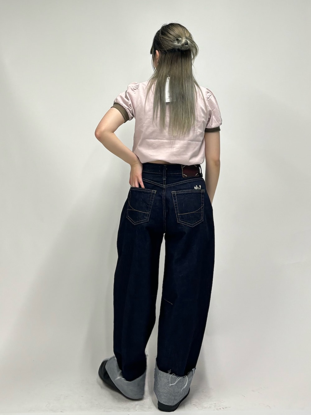 ブルー系のデニムパンツ、ピンク系のポロシャツを着用したレディースの春コーディネートの3枚目の写真