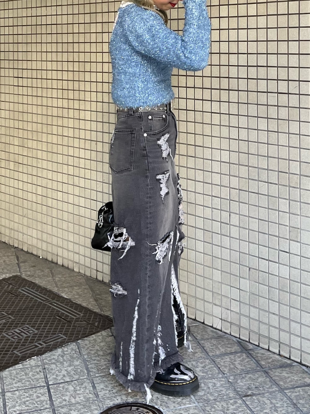 ホワイト系のTシャツ/カットソー、ブラック系のハンドバッグ、ブルー系のニット/セーターを着用したレディースの冬コーディネートの3枚目の写真