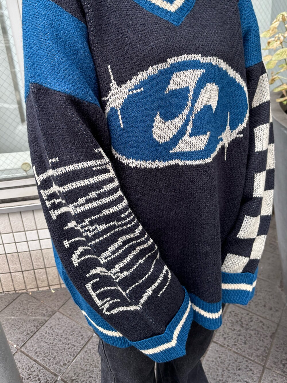 ブラック系のニット/セーター、ホワイト系のTシャツ/カットソー、ブラック系のその他パンツを着用したレディースの秋コーディネートの5枚目の写真