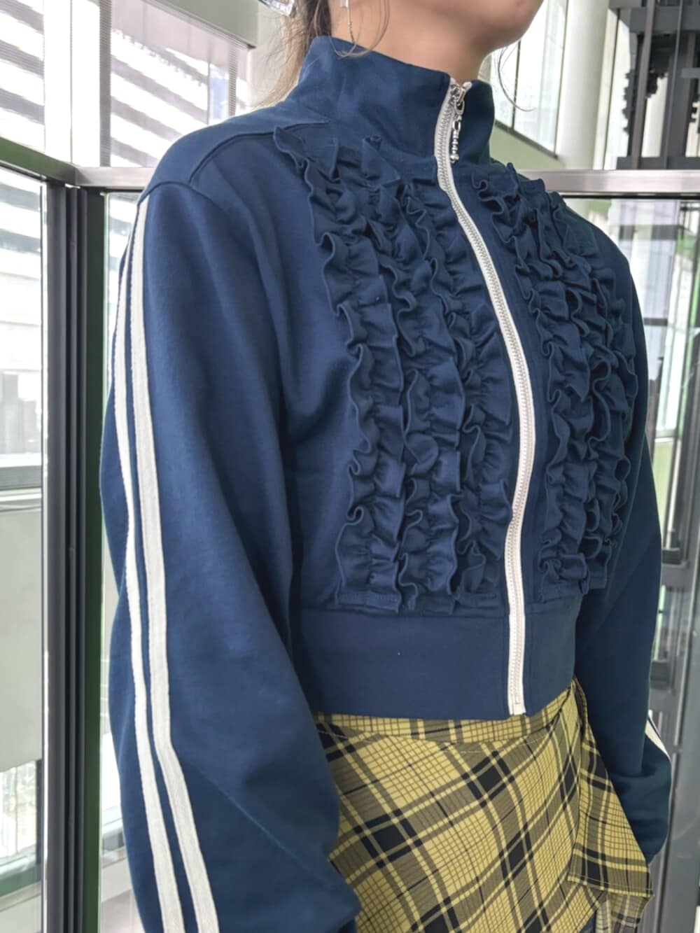 ブラック系のその他シューズ、ブルー系のジャージ、イエロー系のスカートを着用したレディースの春コーディネートの7枚目の写真