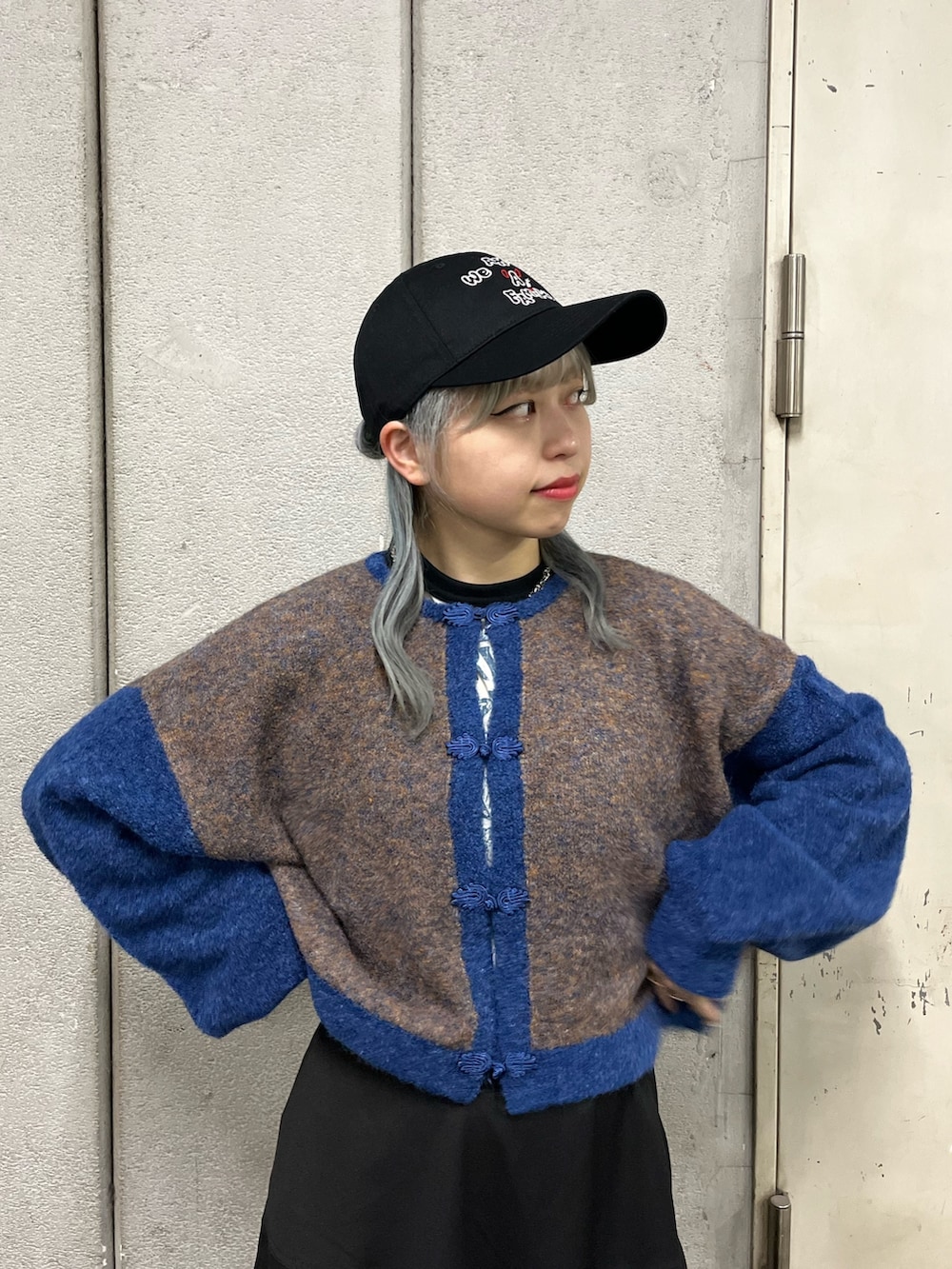 ホワイト系のTシャツ/カットソー、ブラック系のスカート、ブルー系のカーディガン/ボレロを着用したレディースの秋コーディネートの4枚目の写真