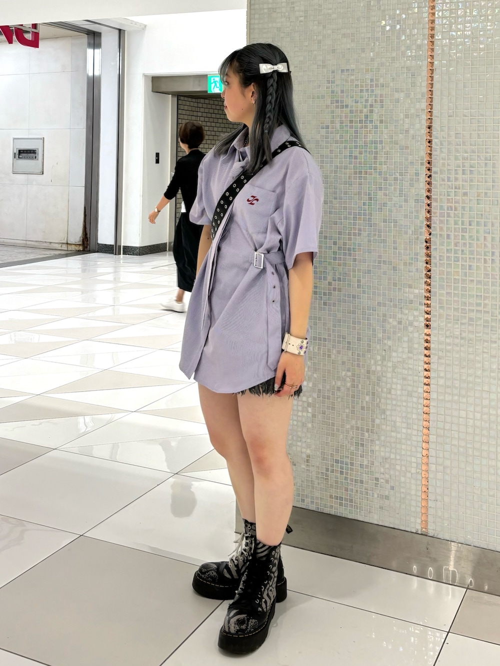 ブラック系のデニムパンツ、ブラック系のショルダーバッグ、パープル系のシャツ/ブラウスを着用したレディースの夏コーディネートの2枚目の写真