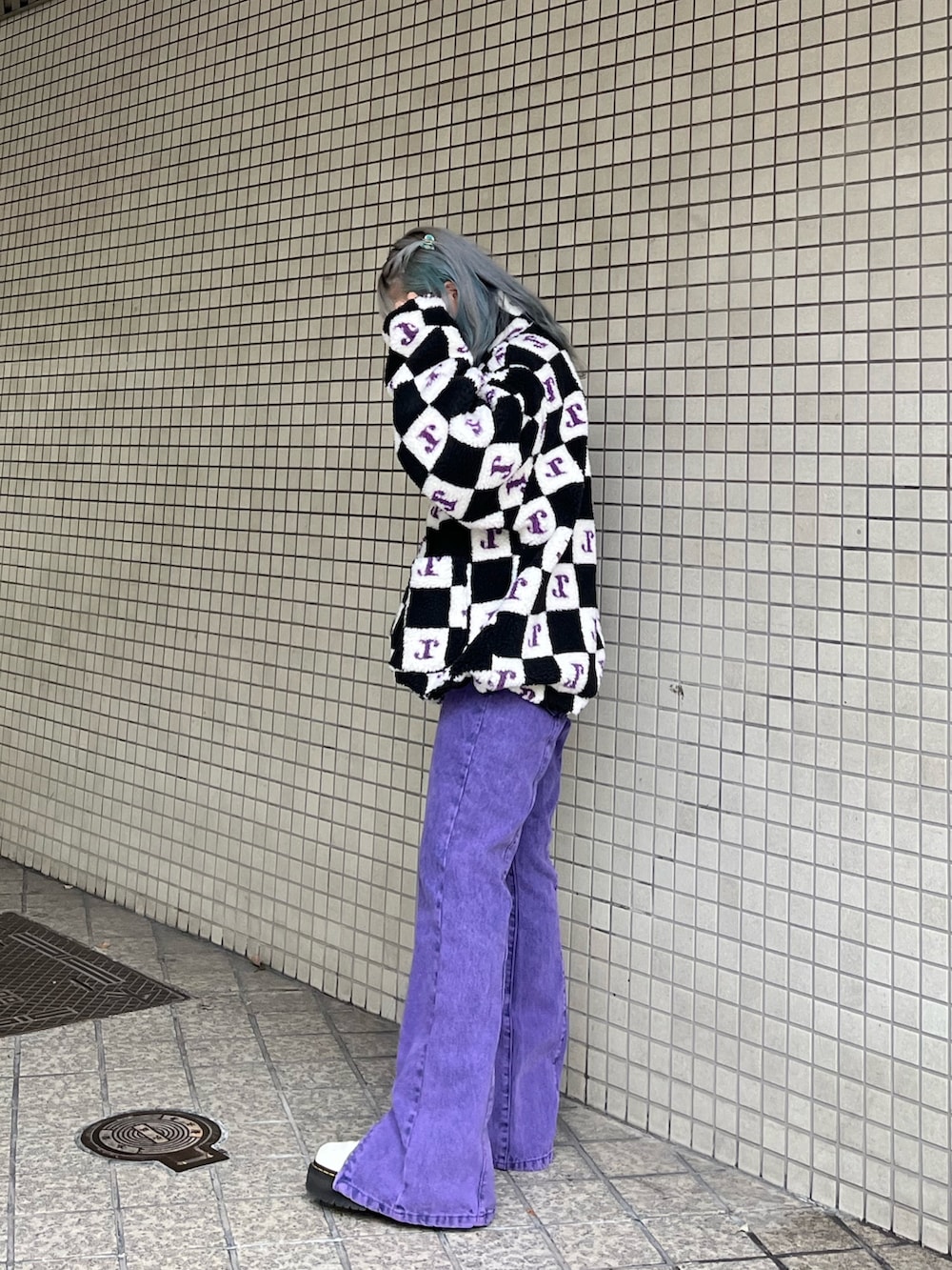 パープル系のデニムパンツ、ブラック系のブルゾンを着用したレディースの秋コーディネートの3枚目の写真