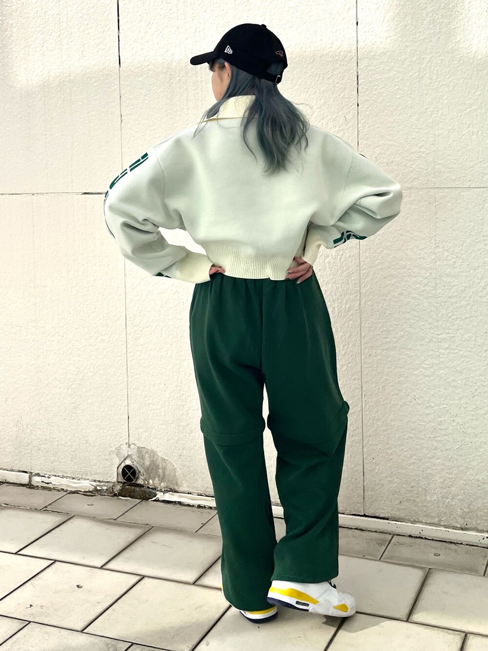 グリーン系のスウェットパンツ、ホワイト系のニット/セーター、シルバー系のネックレスを着用したレディースの冬コーディネートの4枚目の写真