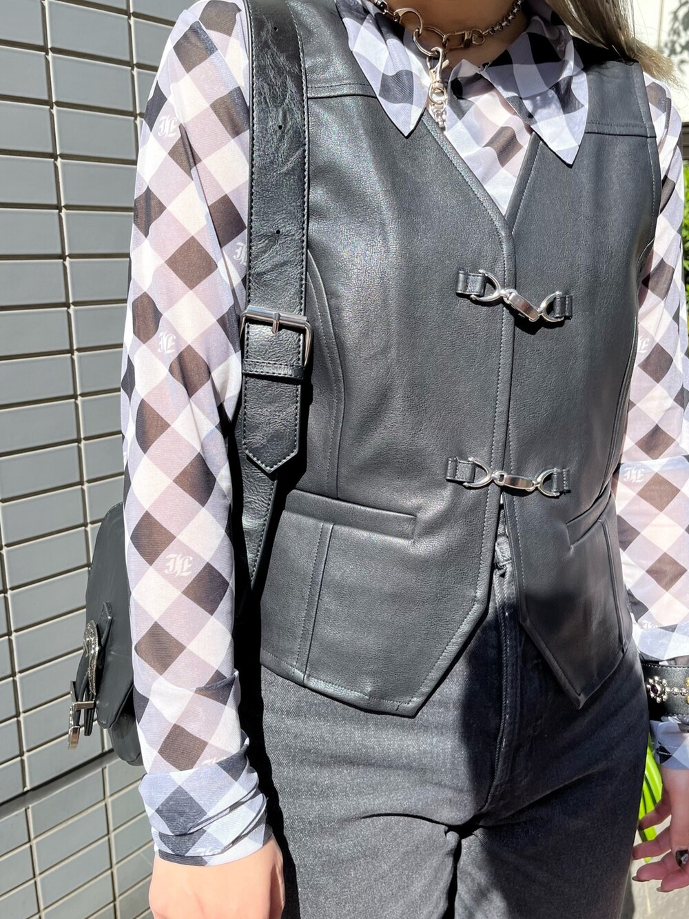 ブラック系のベスト、ブラック系のデニムパンツ、ブラック系のシャツ/ブラウスを着用したレディースの春コーディネートの7枚目の写真