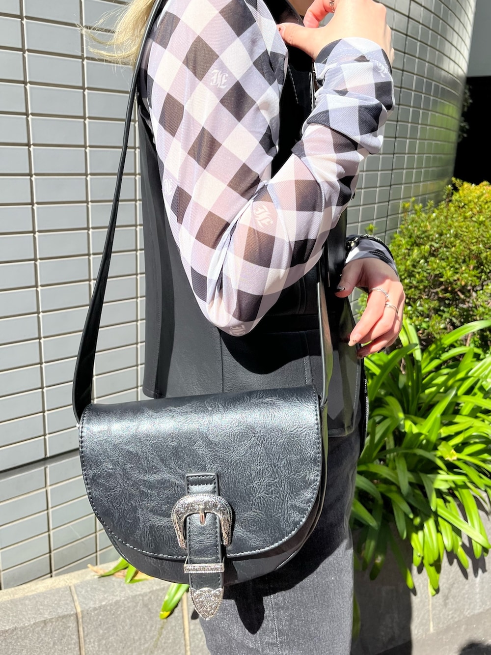 ブラック系のベスト、ブラック系のデニムパンツ、ブラック系のシャツ/ブラウスを着用したレディースの春コーディネートの6枚目の写真