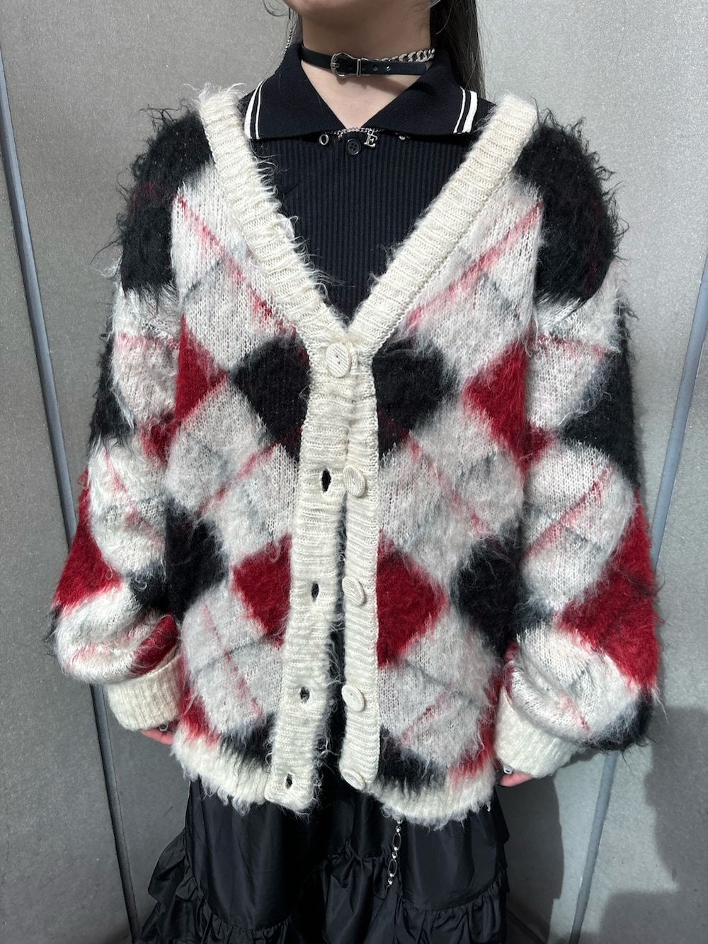 ブラック系のスカート、ホワイト系のカーディガン/ボレロ、ブラック系のTシャツ/カットソーを着用したレディースの秋コーディネートの5枚目の写真