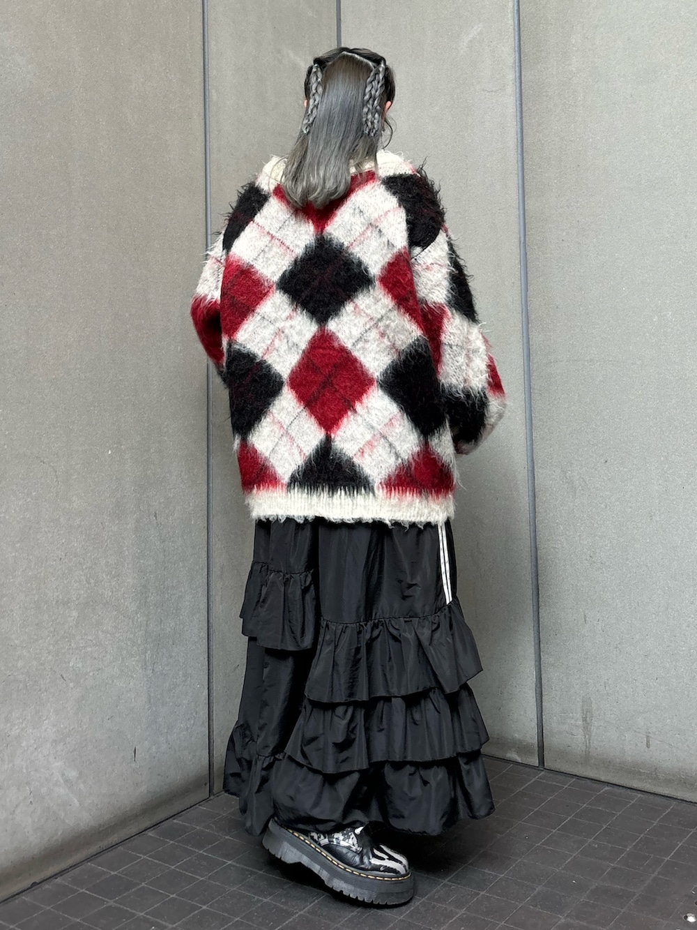 ブラック系のスカート、ホワイト系のカーディガン/ボレロ、ブラック系のTシャツ/カットソーを着用したレディースの秋コーディネートの3枚目の写真