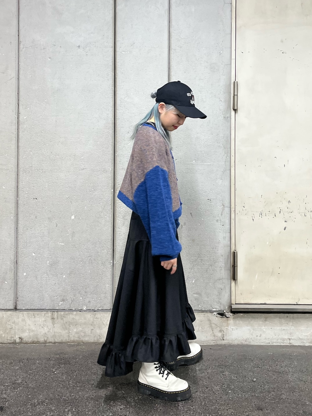 ホワイト系のTシャツ/カットソー、ブラック系のスカート、ブルー系のカーディガン/ボレロを着用したレディースの秋コーディネートの2枚目の写真