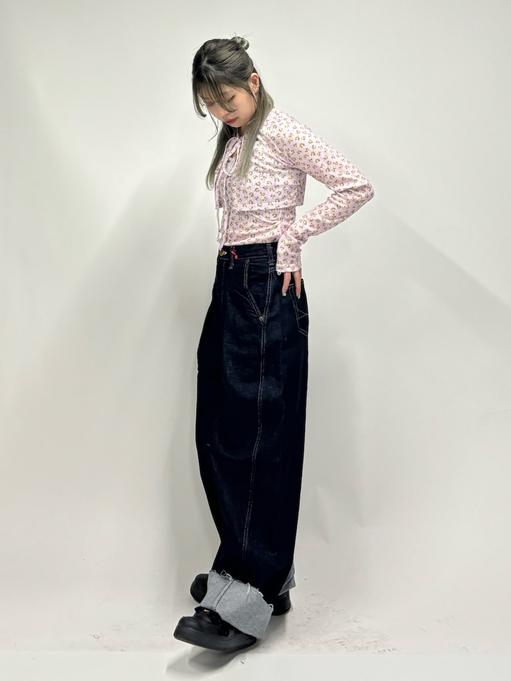 ブルー系のデニムパンツ、ピンク系のアンサンブルを着用したレディースの春コーディネートの4枚目の写真