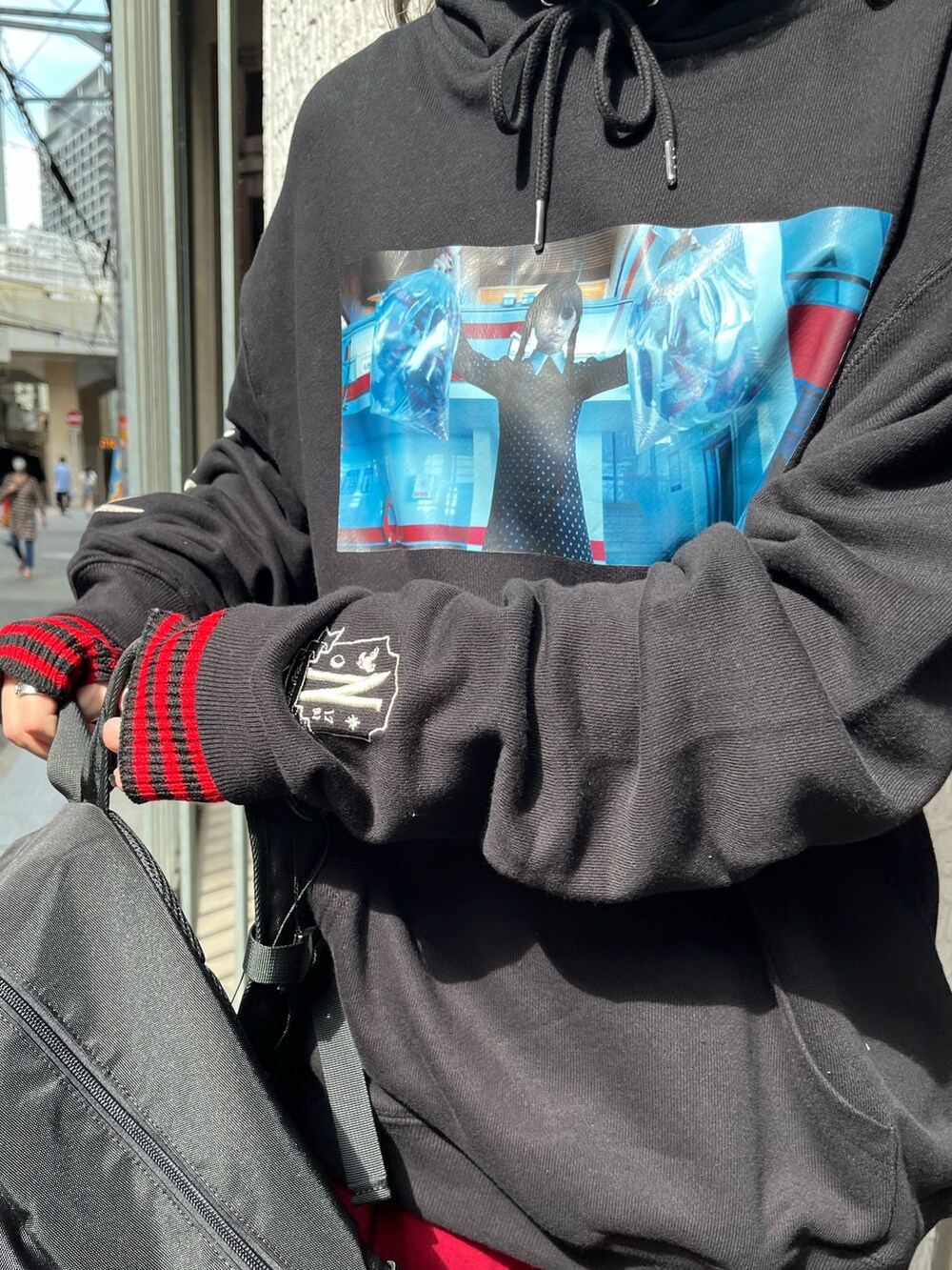 ブラック系のバックパック/リュック、ブラック系のパーカー、レッド系のその他パンツを着用したレディースの秋コーディネートの6枚目の写真