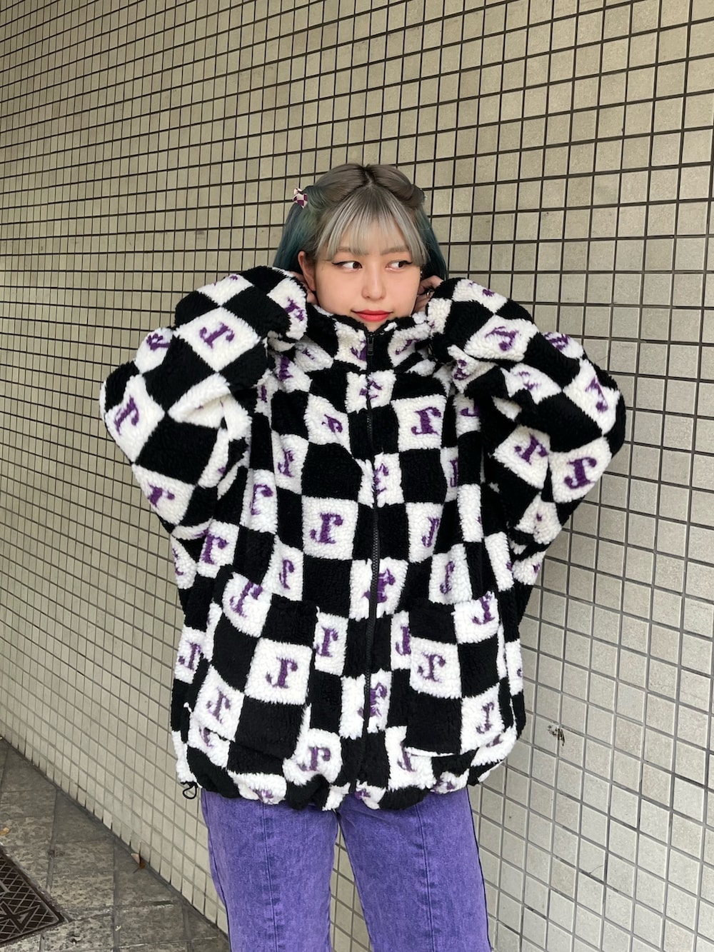 パープル系のデニムパンツ、ブラック系のブルゾンを着用したレディースの秋コーディネートの4枚目の写真