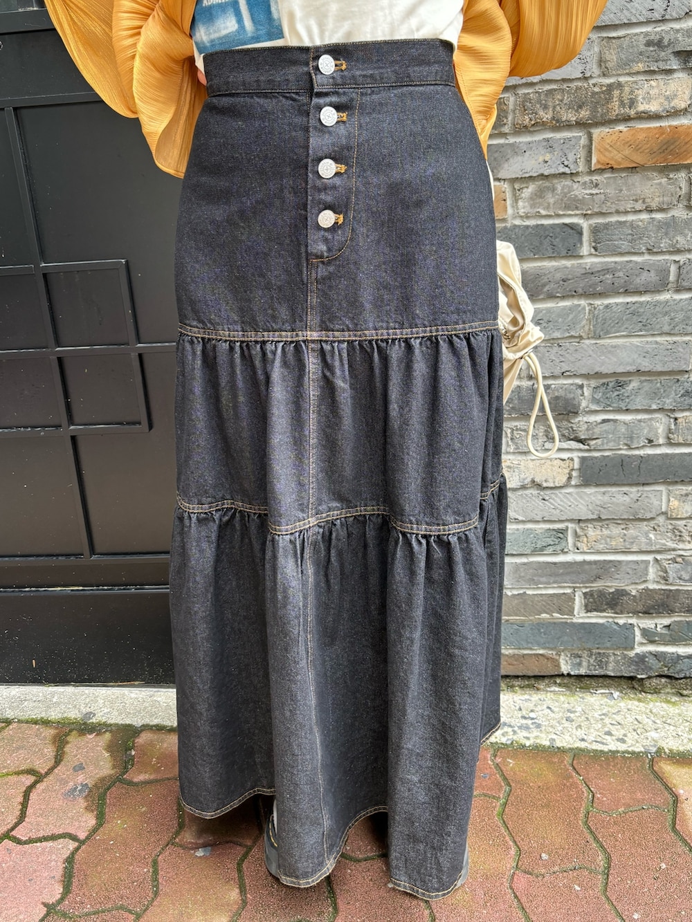 オレンジ系のシャツ/ブラウス、ホワイト系のTシャツ/カットソー、ホワイト系のショルダーバッグを着用したレディースの春コーディネートの9枚目の写真