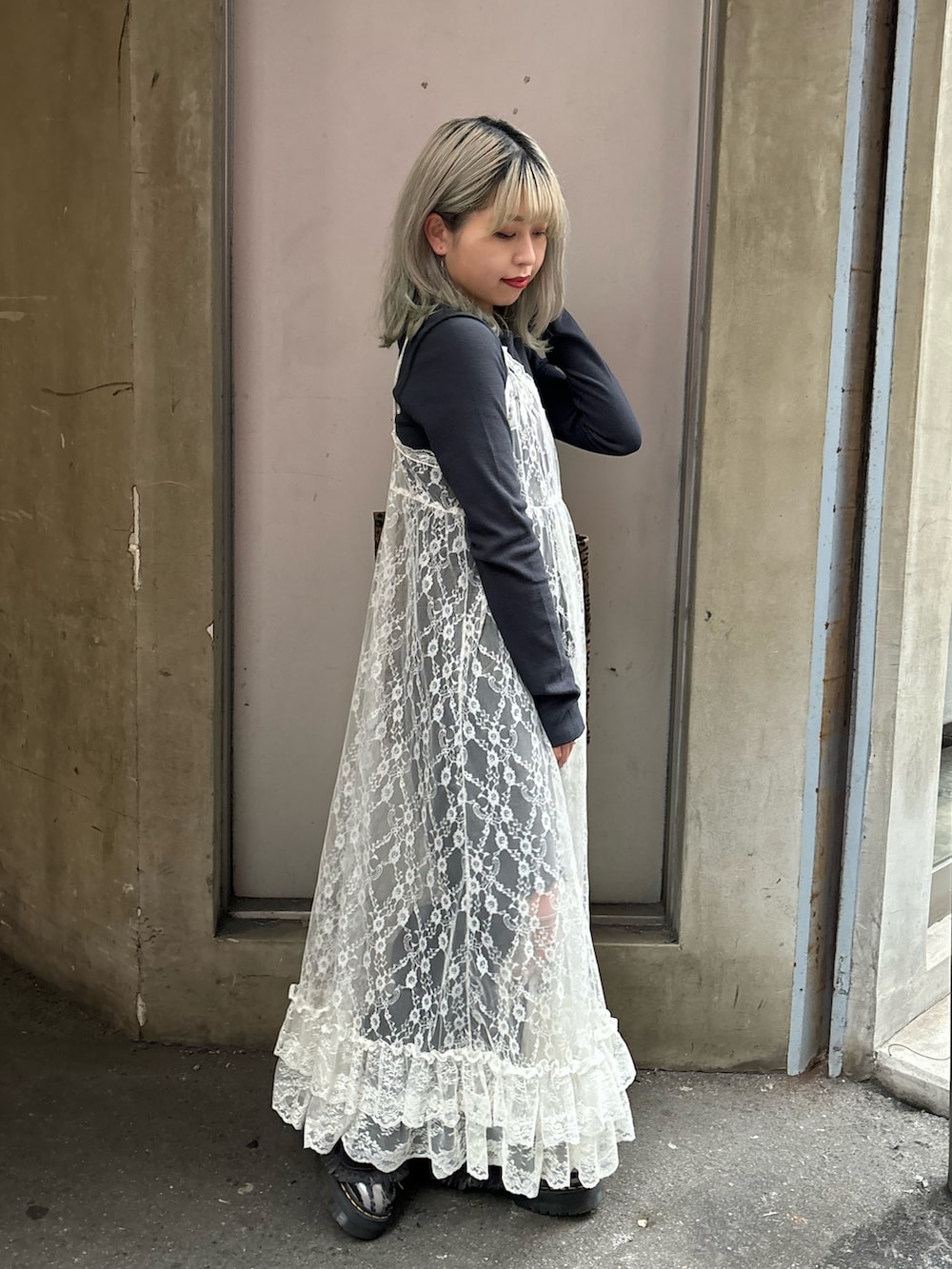 ホワイト系のワンピース、ブラック系のデニムパンツ、その他のトートバッグを着用したレディースの春コーディネートの2枚目の写真