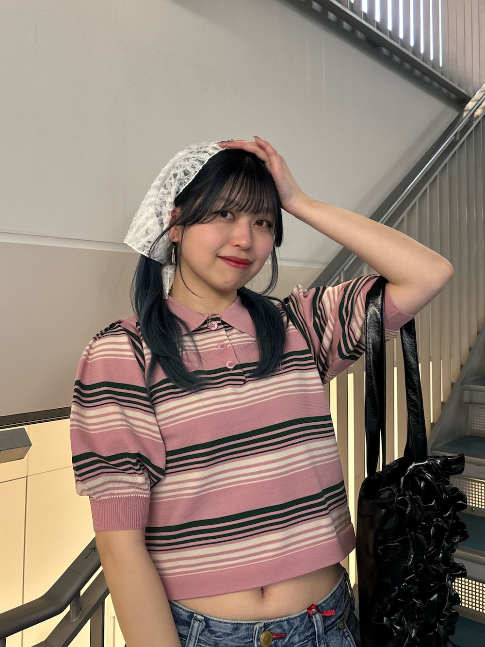 ブラック系のトートバッグ、ブルー系のデニムパンツ、ブルー系のデニムパンツを着用したレディースの春コーディネートの4枚目の写真