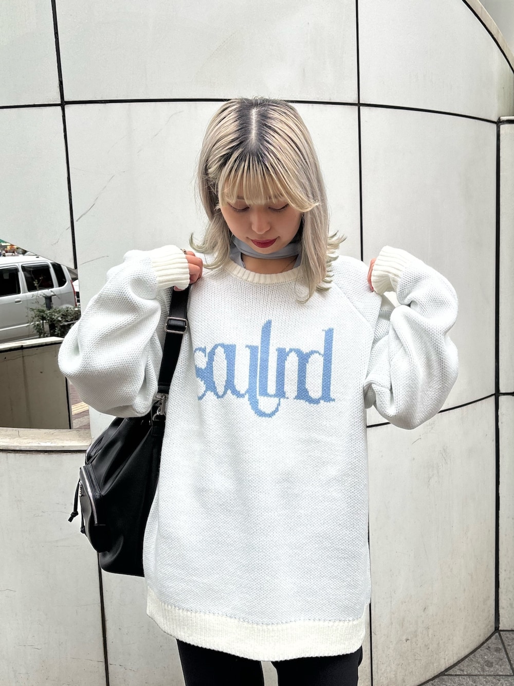 ホワイト系のニット/セーター、ブルー系のシャツ/ブラウス、ブラック系のバックパック/リュックを着用したレディースの春コーディネートの5枚目の写真