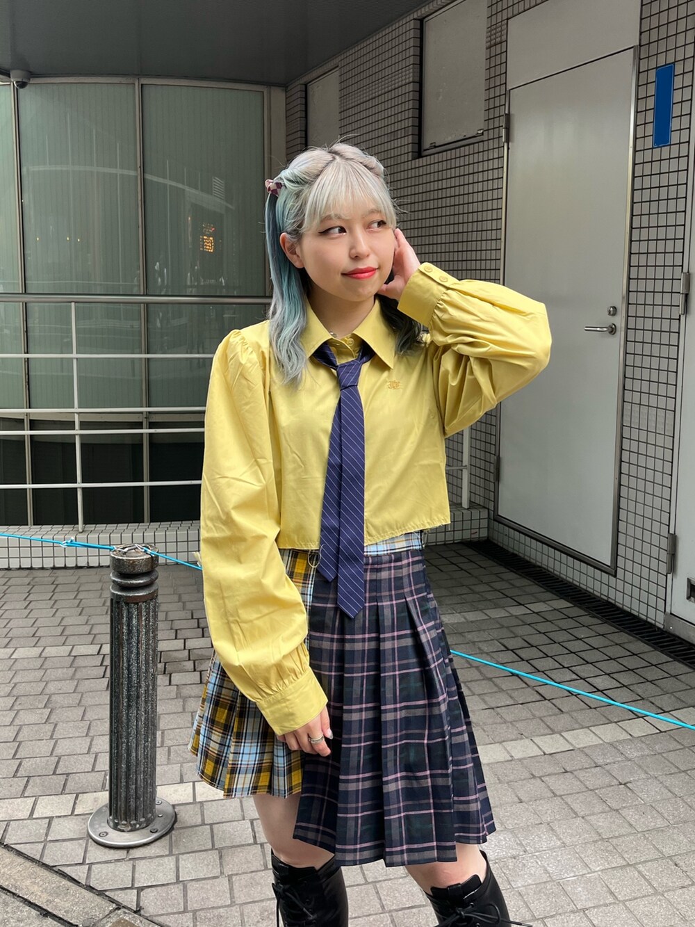 ブルー系のスカート、イエロー系のシャツ/ブラウス、ブラック系のブーツを着用したレディースの冬コーディネートの5枚目の写真